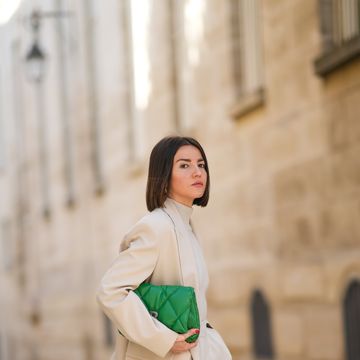 paris, france october 19 alexandra pereira wears silver earrings, a beige turtleneck pullover, matching beige wool large pants, a beige blazer jacket, a green shiny leather quilted handbag, white with green logo leather sneakers from nike, rings, on october 19, 2021 in paris, france photo by edward berthelotgetty images