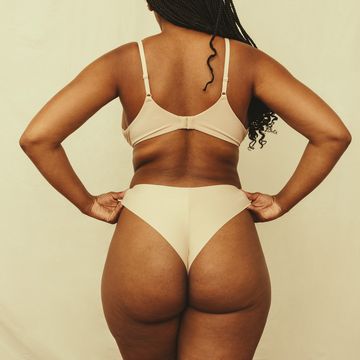 rearview of a self confident young woman adjusting her underwear in a studio anonymous young woman embracing her natural body and curves woman wearing beige underwear against a studio background