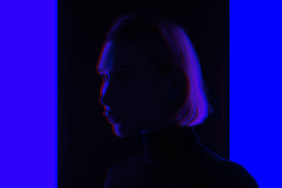 double exposure portrait a transgender woman in standing on blue glowing colored background, futuristic concept studio shots