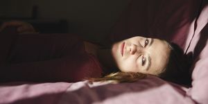 emotionally stressed woman lying on bed at home
