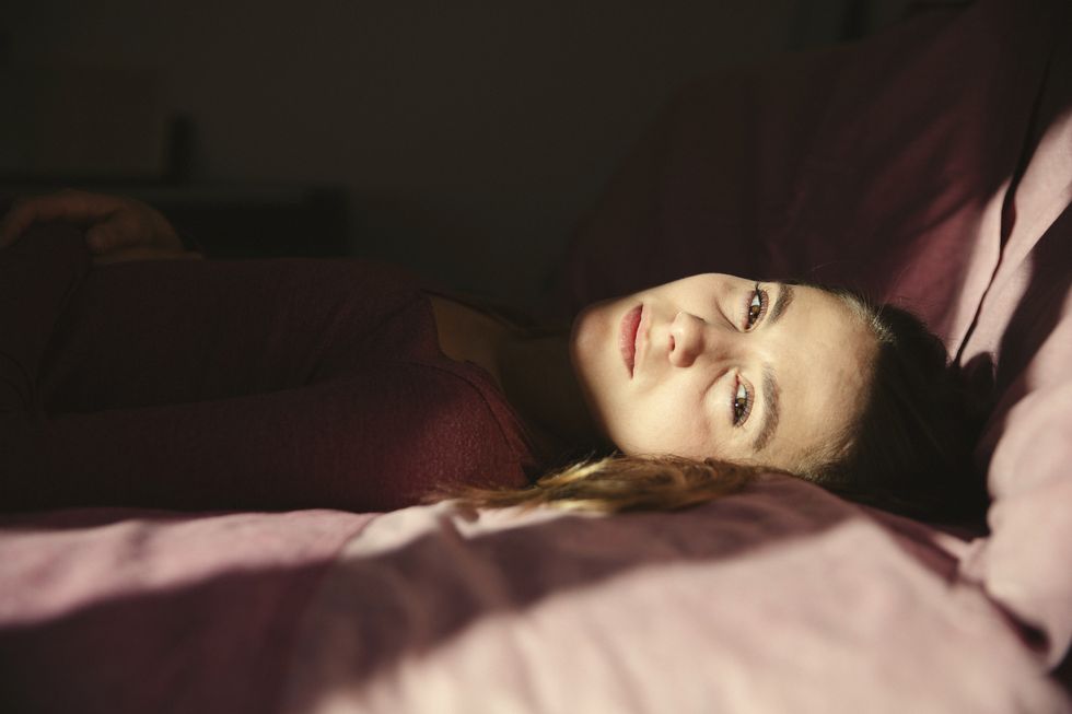 emotionally stressed woman lying on bed at home