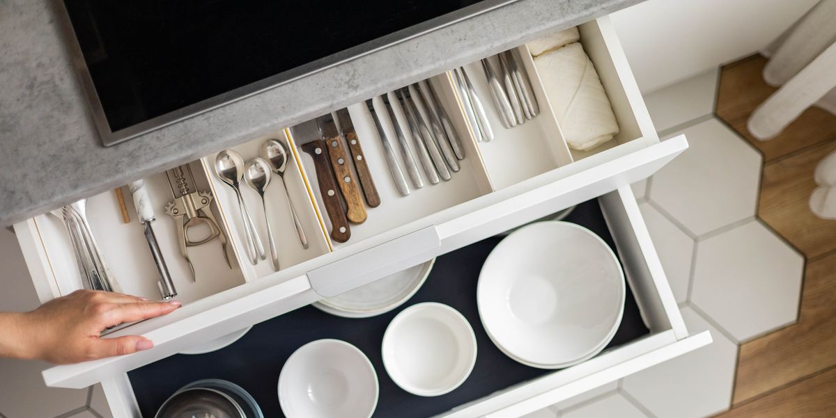 top view modern housewife tidying up kitchen cupboard during general cleaning or tidying up female neatly placing dishware and cutlery in drawer of table storage organization konmati method