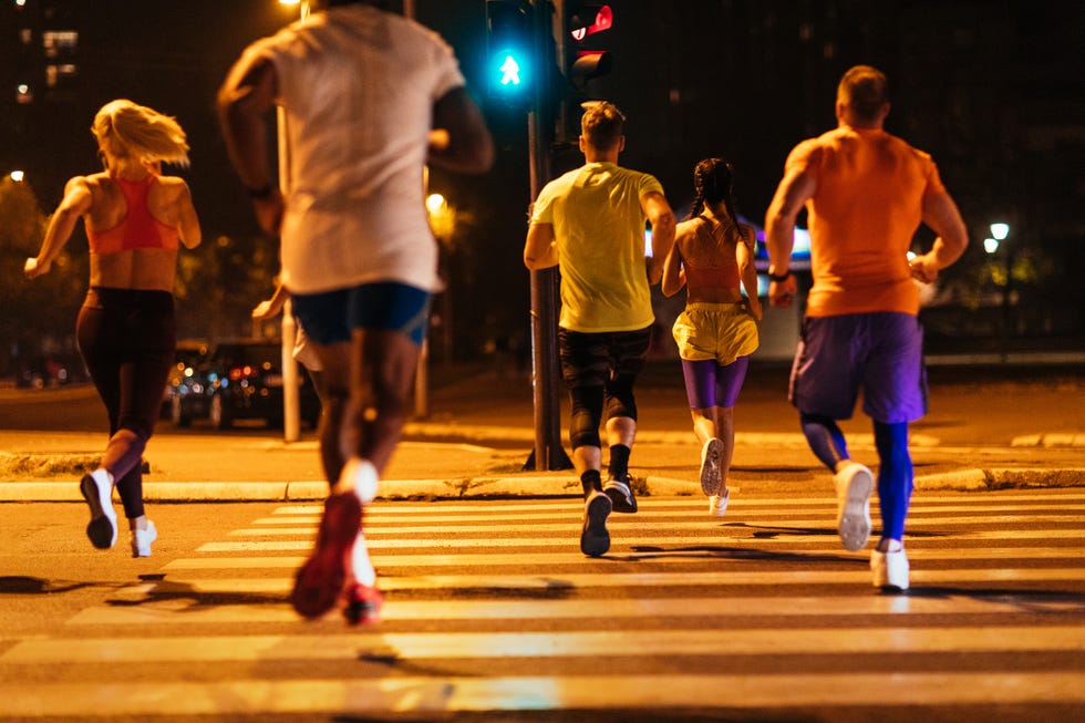 back shot of a group of unrecognizable people running together in the city streets