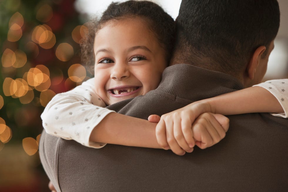 Ideas de fotografías familiares navideñas - padre abrazando a su hija en navidad