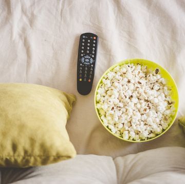 bowl of popcorn with tv remote control