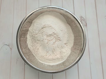 close up of flour in stainless steel mixing bowl