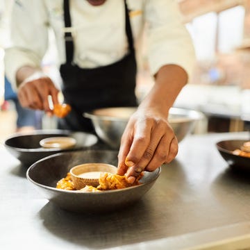 Restaurant chef preparing a dish close up of male chef arranging food on a dish in the commercial kitchen