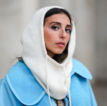 vrouw met witte balaclava en blauwe jas