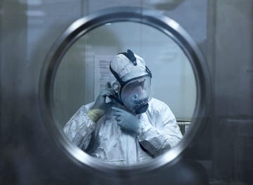 Een viroloog van het Vincents Hospitals Centre for Applied Medical Research in Sydney doet op 8 december 2021 zijn beschermende kleding goed tijdens een onderzoek naar de omikronvariant De varianten omikron BA4 en BA5 zijn nog steeds belangrijke oorzaken van herbesmettingen