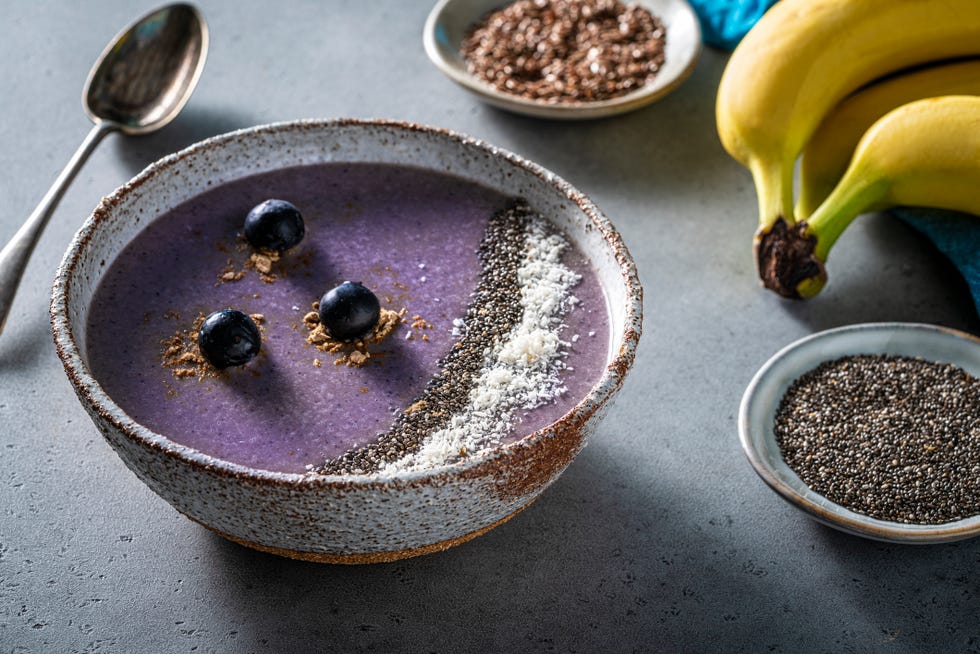 blueberry smoothie breakfast bowl vegan recipe including ingredients as blueberries, banana, walnuts, oat flakes, maca powder, chia seeds and almond milk