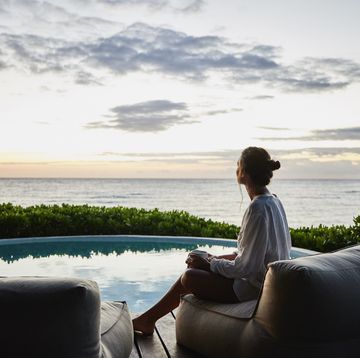 a person sitting on a couch looking out at the ocean