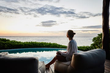 a person sitting on a couch looking out at the ocean