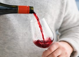 man pouring sparkling red wine into the glass