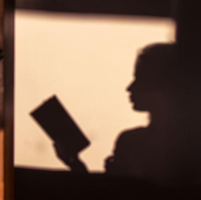 vintage silhouette of a young beautiful woman at sunrise sitting on a chair and sitting on a chair and concentrating on reading