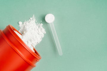 creatine powder vitamin and sports supplement concept over isolated background.