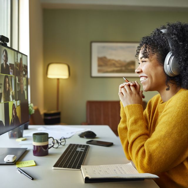 businesswoman with headphones smiling during video conference multiracial male and female professionals are attending online meeting they are discussing business strategy