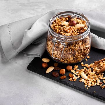 homemade healthy granola made of oats nuts and fruits on black stone background copy space