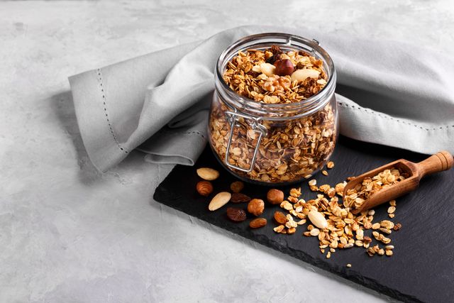 homemade healthy granola made of oats nuts and fruits on black stone background copy space