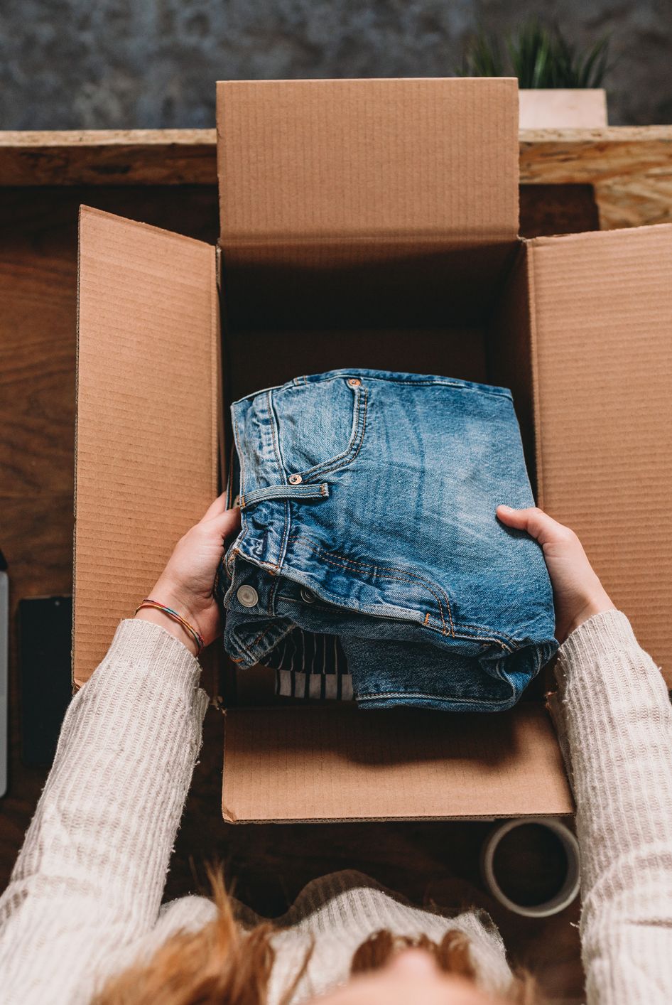 a millennial woman is preparing the shipment of some clothes in her new online shop shes the owner of an online thrift store new small business concept