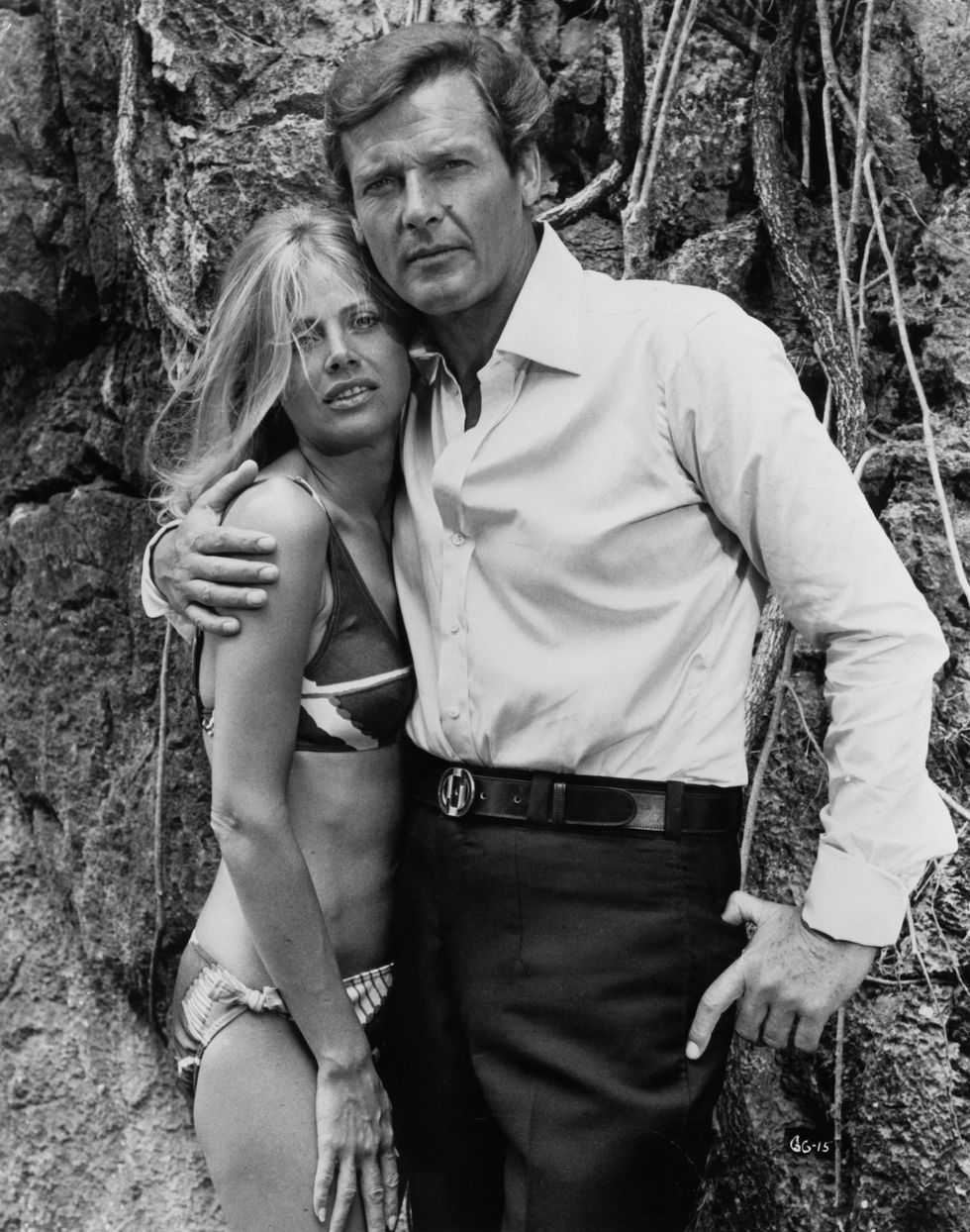 roger moore with his arm around britt ekland, wearing a bikini in a scene from the film 'the man with the golden gun', 1974 photo by united artistsgetty images