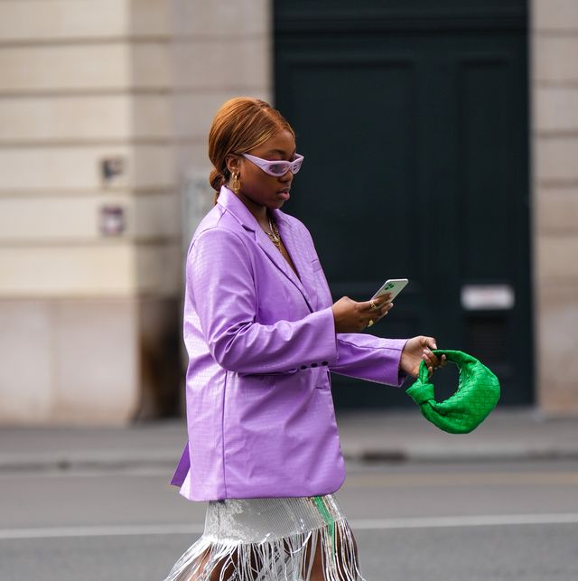 paris, france   march 01 a guest wears pale purple sunglasses, gold pendant earrings, a pale purple shiny leather crocodile print pattern blazer jacket, silver and gold chain pendant necklace, a black v neck tank top, a silver and green sequined print pattern fringed midi skirt, silver sequined pointed  block heels knees boots  high boots, gold rings, a green shiny braided leather jodie handbag from bottega veneta, outside nanushka, during paris fashion week   womenswear fw 2022 2023, on march 01, 2022 in paris, france photo by edward berthelotgetty images