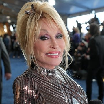 dolly parton smiles at the camera in a patterned sequin dress with a butterfly clip in her hair while at the 57th academy of country music awards at allegiant stadium on march 07, 2022 in las vegas, nevada photo by kevin mazurgetty images for acm