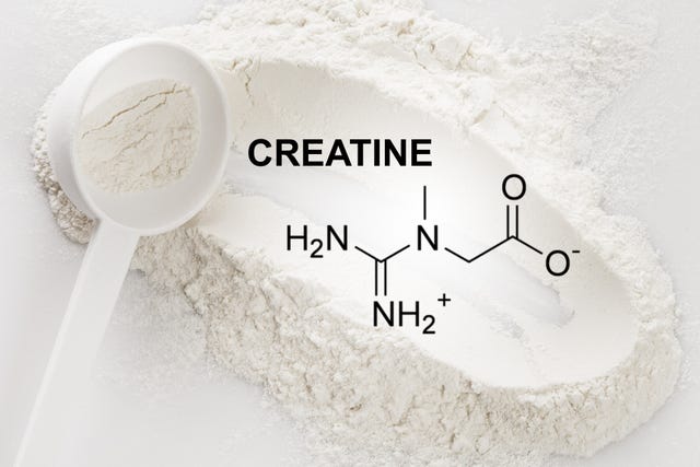 closeup of scoop with creatine monohydrate supplement and chemical formula