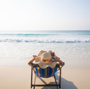woman relaxing in lawn chair on beach