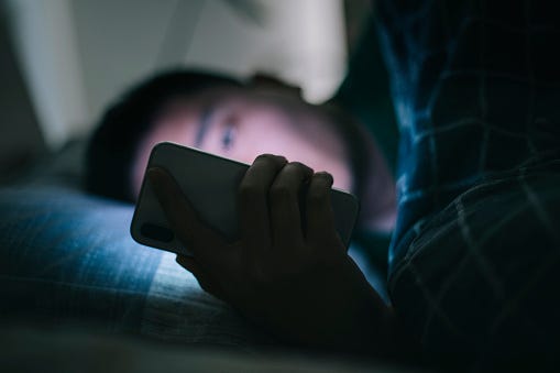 man in bed on phone