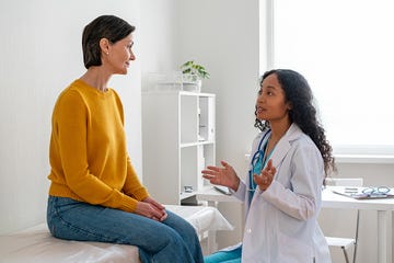 young mental health professional african american talking to female mature patient in medical clinic concept of mental wellbeing supportive and positive atmosphere in hospital