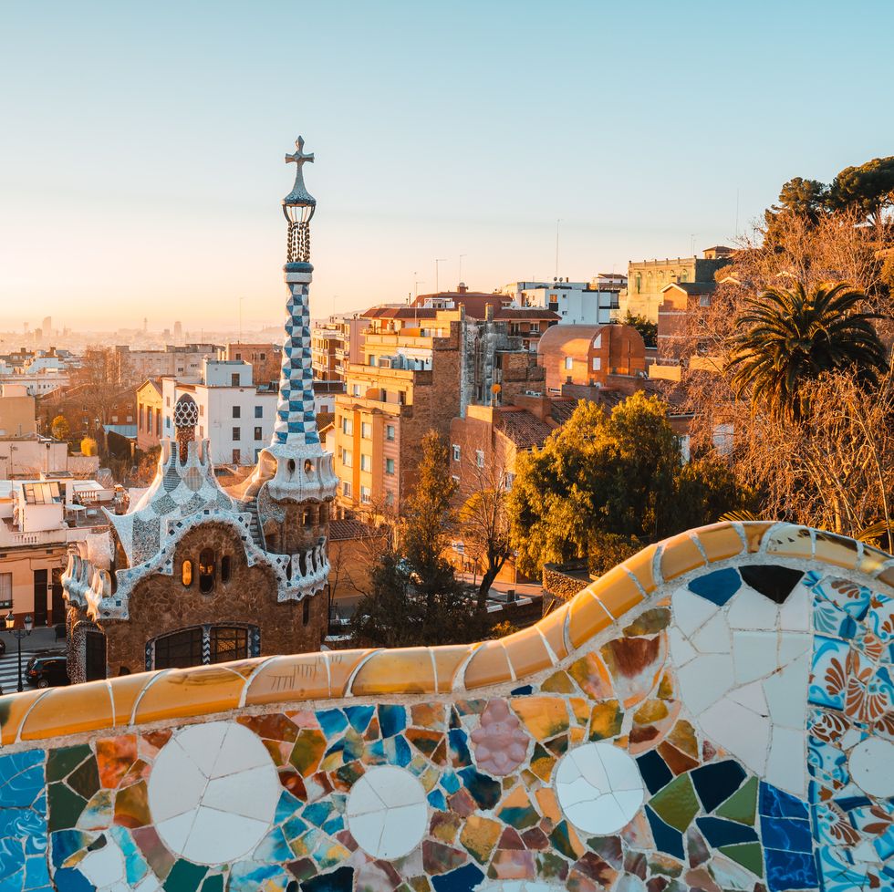 view of the city from park guell in barcelona, spain with sunrise colors