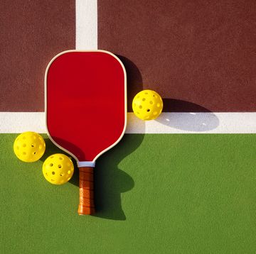 this is a photograph taken outside of a pickleball paddle and balls on a outdoor court