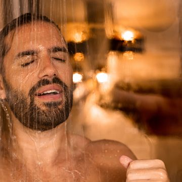 man taking a shower washing hair only with hands showering person at home lifestyle young adult body care morning routine