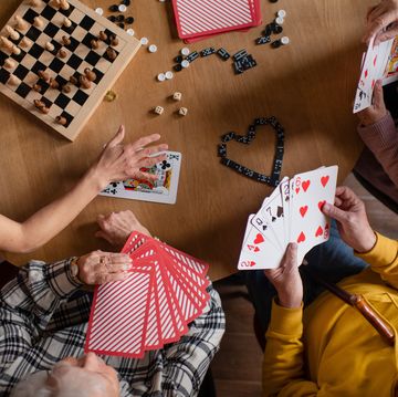 cheerful group of seniors playing board games at nursing home