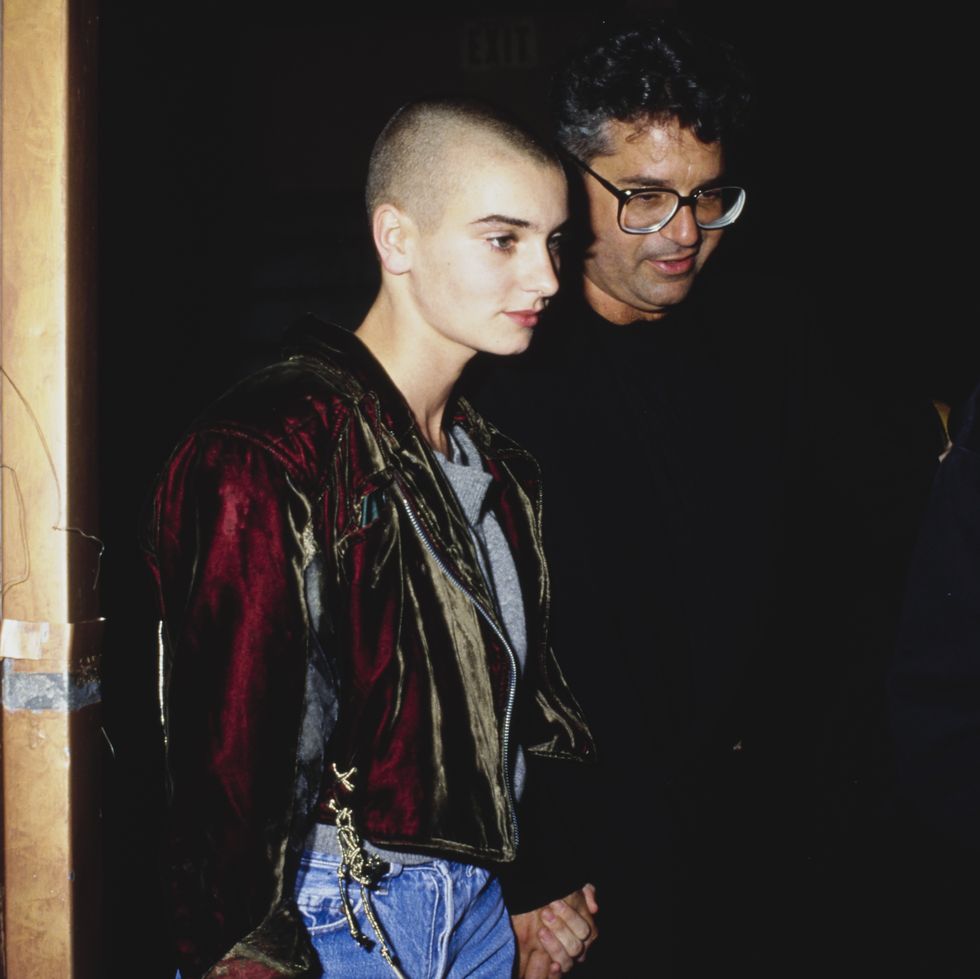 Irish singer-songwriter Sinead Oconnor wearing a red velvet jacket over a gray T-shirt, accompanied by a man, USA, circa 1990.  Photo by Vinnie Zuffantemichael ochs archivesgetty images
