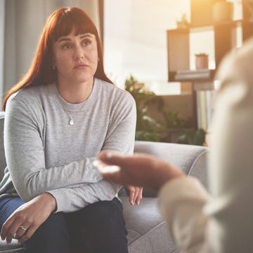 a woman talking to a psychologist or therapist a young woman looking sad while getting help during a therapy session with a counsellor
