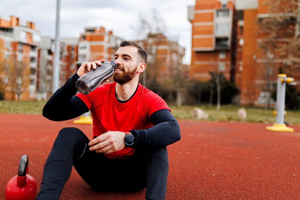 fit man drinking water after intensive work out