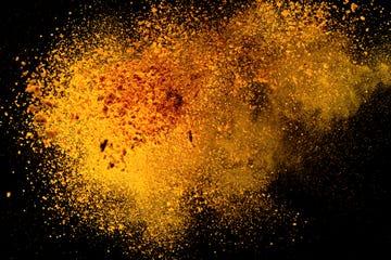 explosion, splashes of turmeric on a black background india seasoning the orange powder of the turmeric root explosion of powder