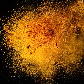 Explosion, Splashes of turmeric on a black background. India Seasoning. The orange powder of the turmeric root. explosion, splashes of turmeric on a black background india seasoning the orange powder of the turmeric root explosion of powder