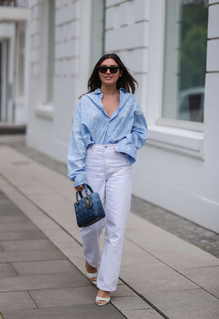 hamburg, germany june 09 milena karl seen wearing a black saint laurent sunglasses, a light blue shirt blouse from hermes, a white denim jeans from monki, creme high heels from gia and a blue leather lady dior bag on june 09, 2022 in hamburg, germany photo by jeremy moellergetty images
