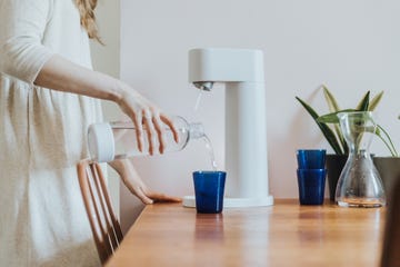 close up of woman making sparkling water at home