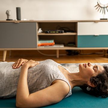 a woman lies on yoga mats and does breathing exercises