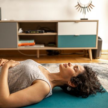 a woman lies on yoga mats and does breathing exercises