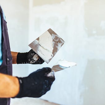 handsome construction worker finishing a facade of interior wall,