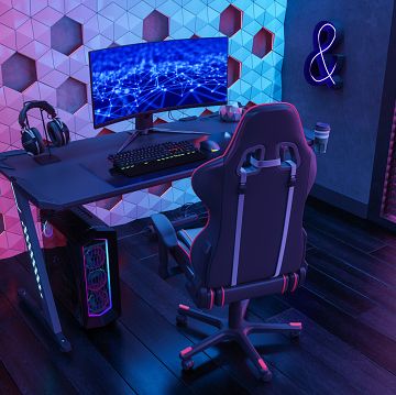 gamer room with gaming chair, computer monitor and neon lights at night
