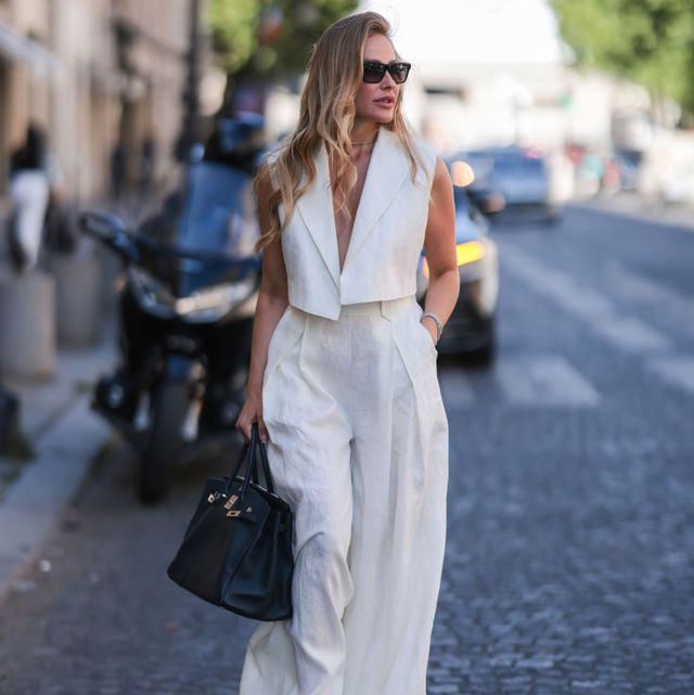 paris, france july 07 ginta seen wearing back sunglasses from yves saint laurent, diamond stud earrings, diamond necklace, a creme white linen suit vest and matching creme white linen suit pants from bequartii, a black leather hermes birkin bag and white sandals from bottega veneta, during paris fashion week haute couture fall winter 2022 2023, on july 07, 2022 in paris, france photo by jeremy moellergetty images