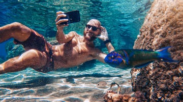 funny man selfie with mobile phone underwater at sea internet addiction