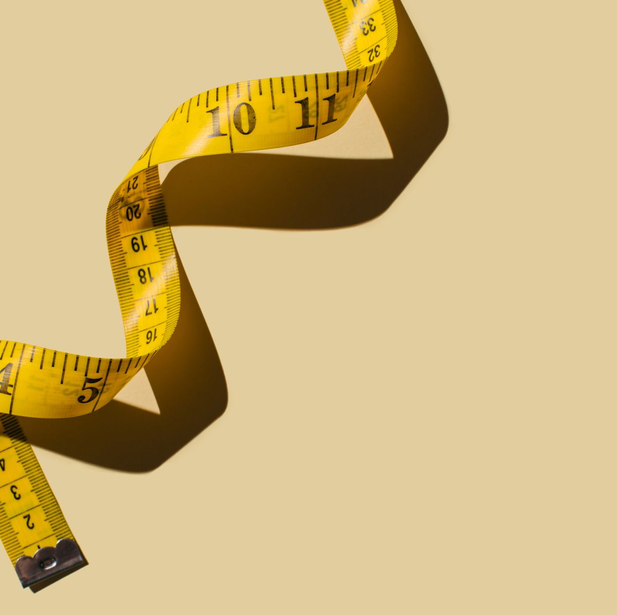 Yellow Tape Measure On A White Background For Measuring Clothing