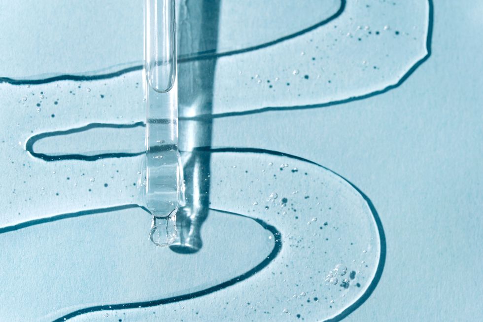 pipette with liquid gel or serum on pastel blue background