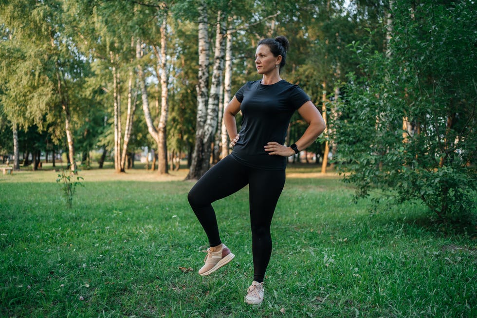 woman warming up in training, outdoor fitness, stretching exercises